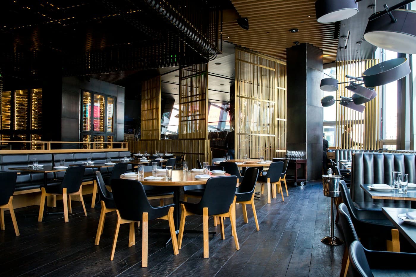 An airy gathering space with long wooden tables and greenery; editorial inspiration